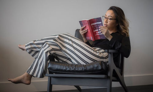 woman relaxing in sofa reading a book