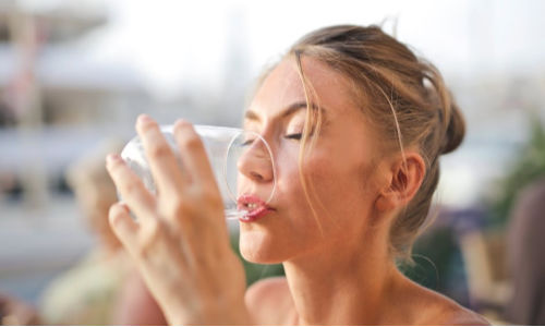 woman drinking water from glass