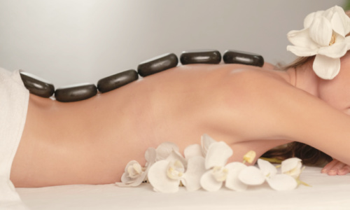 woman lying on massage table with hot massage stones on her back