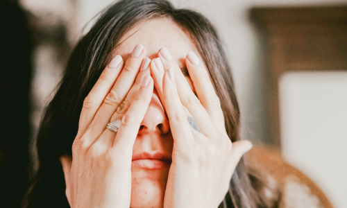woman with hands covering her face