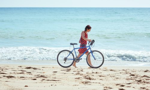 woman with bike near the ocean