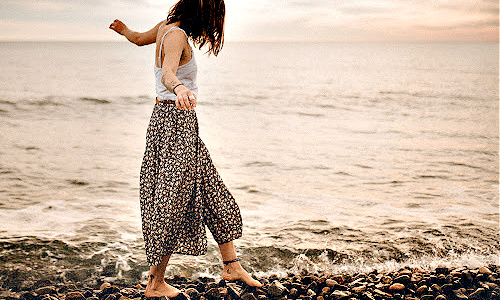 woman walking alongside seashore