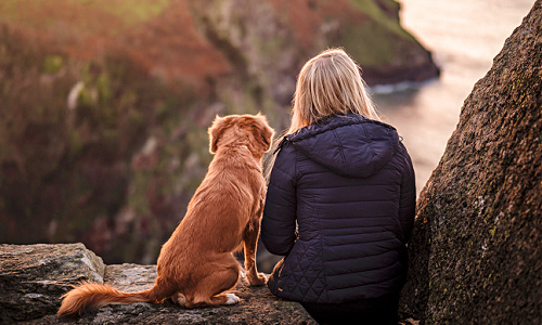 woman and her dog looking out at landscape
