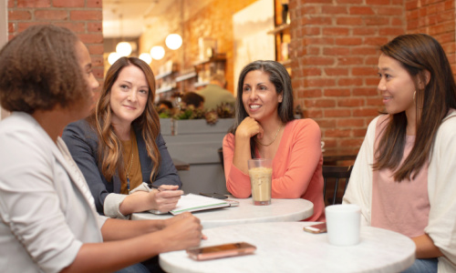 small group of women conversing and smiling