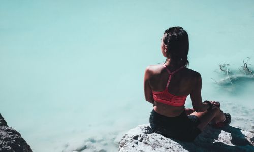 woman sitting on a rock out in nature