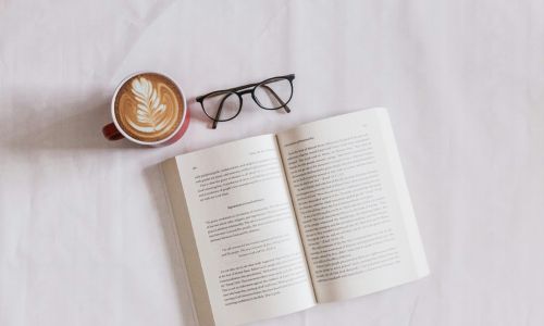 open book with glasses and a cup of coffee